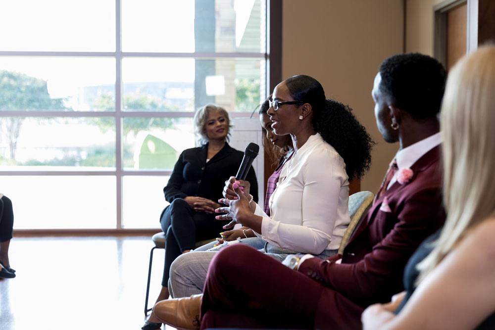 Woman speaking into a microphone during a panel discussion
