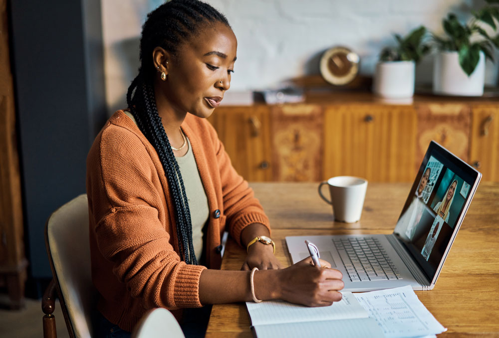 Woman taking notes during an online meeting