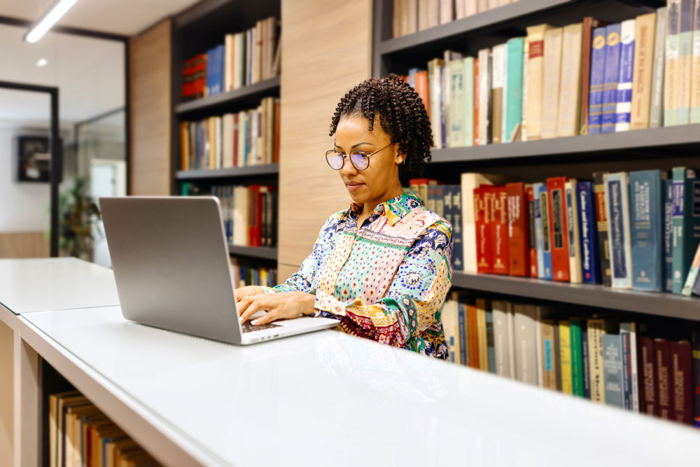 Woman working on a laptop in a library